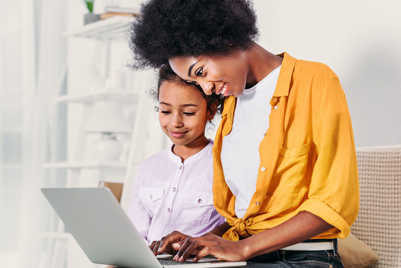 A women with girl watching on laptop